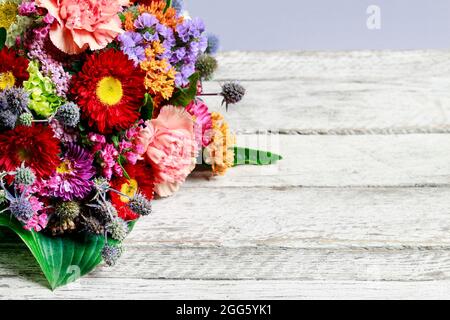 Bouquet de mariage avec œillets et asters sur fond de bois, espace copie. Banque D'Images