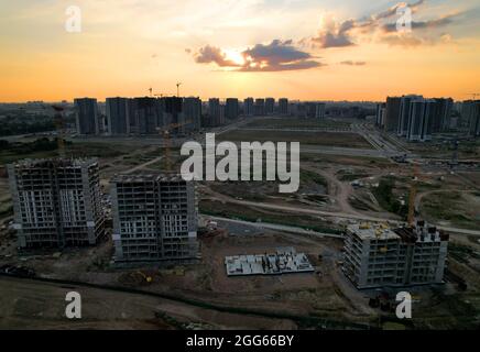 Chantier de construction sur fond de coucher de soleil. Grue de tour pendant les travaux de coffrage sur le bâtiment. Construction des bâtiments et des bâtiments résidentiels à plusieurs étages Banque D'Images