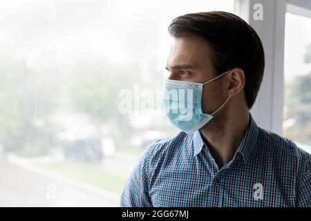 Homme d'affaires millénaire sérieux, sérieux, portant un masque Banque D'Images