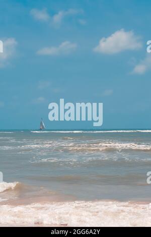 Un petit yacht blanc navigue dans la mer bleue ou l'océan, vagues sur l'eau Banque D'Images