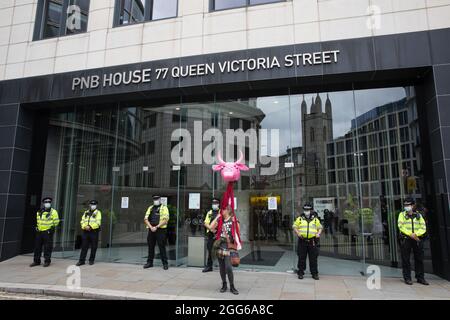 Londres, Royaume-Uni. 28 août 2021. Un militant des droits des animaux se tient devant les officiers de la police métropolitaine qui gardent les bureaux de Cargill lors d'une Marche nationale des droits des animaux par la rébellion animale et d'autres groupes. La rébellion animale, une branche de la rébellion d'extinction, a organisé la marche pour le sixième jour de l'extinction des manifestations impossibles de la rébellion de la rébellion à Londres. Cargill est l'un des plus grands transformateurs de viande au monde. Crédit : Mark Kerrison/Alamy Live News Banque D'Images