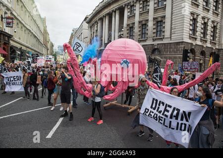 Londres, Royaume-Uni. 28 août 2021. Les activistes de la rébellion océanique tiennent un poulpe rose modèle lors d'une Marche nationale des droits des animaux. Animal Rebellion, une autre branche de l'extinction Rebellion, a organisé la marche pour le sixième jour de l'extinction Rebellion manifestations à Londres, avec des arrêts sur le marché de la viande de Smithfield, Unilever (qui possède des marques qui vendent des produits laitiers et utilisent de l'huile de palme), Cargill (qui est l'un des plus grands transformateurs de viande au monde) Et le Conseil de gérance de la mer. Crédit : Mark Kerrison/Alamy Live News Banque D'Images