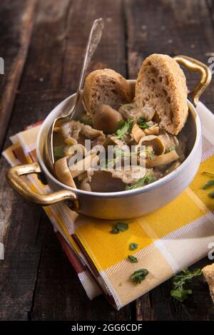 Marquage de présentation de la soupe aux champignons en pioppini sur table noire Banque D'Images