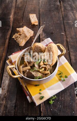 Marquage de présentation de la soupe aux champignons en pioppini sur table noire Banque D'Images