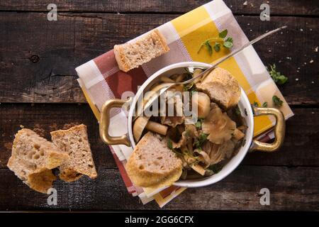 Marquage de présentation de la soupe aux champignons en pioppini sur table noire Banque D'Images