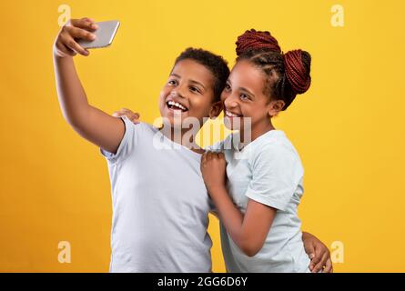Amoureux afro-américains aimant prendre selfie ensemble sur téléphone portable Banque D'Images