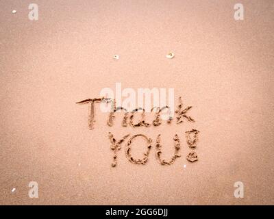 Merci pour les mots écrits ou dessinés sur le sable propre de la plage avec le ciel bleu le matin. Banque D'Images