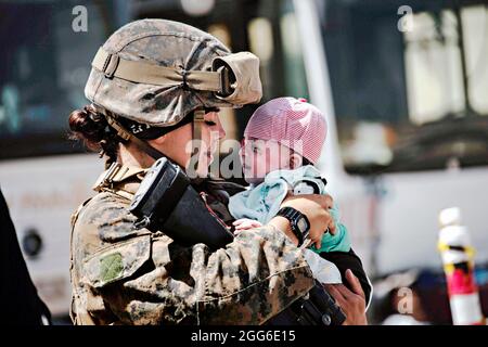 Kaboul, Afghanistan. 28 août 2021. Une marine américaine avec la 24e unité expéditionnaire maritime calme un nourrisson en attente d'évacuation à l'aéroport international Hamid Karzaï pendant le refuge de l'opération alliés le 28 août 2021 à Kaboul, en Afghanistan. Credit: Planetpix/Alamy Live News Banque D'Images