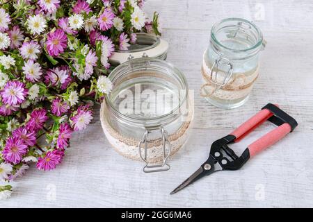 Comment faire un bouquet de fleurs insidea un vase en verre décoré de dentelle. Étape par étape, tutoriel. Banque D'Images