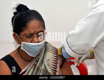 Guwahati, Inde. 29 août 2021. Un agent de santé administre une dose du vaccin COVID-19 à une femme dans un centre de vaccination de Guwahati, en Inde, le 29 août 2021. Credit: STR/Xinhua/Alay Live News Banque D'Images