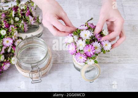 Comment faire un bouquet de fleurs insidea un vase en verre décoré de dentelle. Étape par étape, tutoriel. Banque D'Images