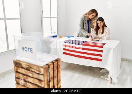 Deux jeunes américaines travaillant à l'université de la table électorale. Banque D'Images