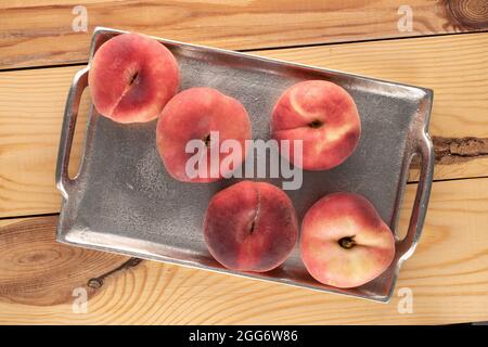 Plusieurs figues de pêche mûres bio avec plateau en métal sur une table en bois, vue rapprochée, vue de dessus. Banque D'Images