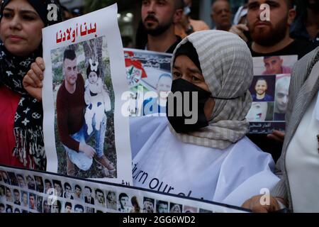 Des Palestiniens portant des boucliers et tenant des photos dans la ville de Naplouse de Palestiniens dont l'armée israélienne tient les corps, ont été tués pendant o Banque D'Images