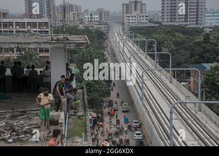 Vue aérienne des gens lors du premier essai officiel dimanche sur les voies de passage des trains du tout premier métro du Bangladesh dans la région de Mirpur. Le 29 août 2021 à Dhaka, au Bangladesh. (Sazzad Hossain / Eyepix Group) Banque D'Images