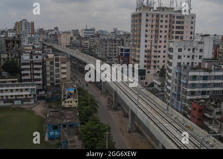 Vue aérienne des gens lors du premier essai officiel dimanche sur les voies de passage des trains du tout premier métro du Bangladesh dans la région de Mirpur. Le 29 août 2021 à Dhaka, au Bangladesh. (Sazzad Hossain / Eyepix Group) Banque D'Images