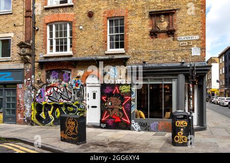 LONDRES ZONE ARTISTIQUE ET CULTURELLE AUTOUR DE LA RUELLE DE BRIQUE AVEC DES DESSINS CRÉATIFS ET DES SLOGANS JONCTION DE LA RUELLE DE BRIQUE ET SCLATER STREET Banque D'Images