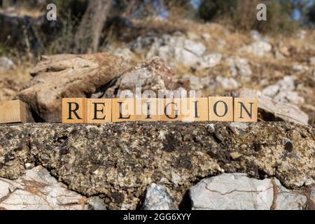 La religion de mot a été créée à partir de cubes en bois. Photographié sur le mur. Gros plan. Banque D'Images