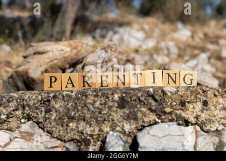 Le mot de parenting a été créé à partir de cubes en bois. Photographié sur le mur. Gros plan. Banque D'Images