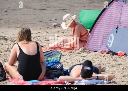 Gower, Swansea, Royaume-Uni. 29 août 2021. Météo Royaume-Uni. Les amateurs de plage apprécient un après-midi chaud et ensoleillé le week-end de vacances d'août à la plage de Llangennith sur la péninsule de Gower. Le reste du week-end de vacances devrait être tout aussi bien dans le sud. Crédit : Gareth Llewelyn/Alay Banque D'Images