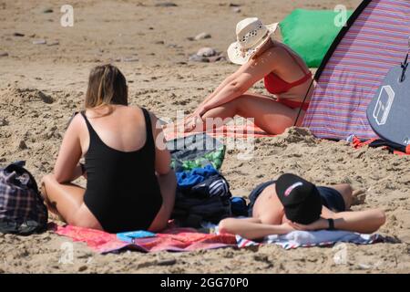 Gower, Swansea, Royaume-Uni. 29 août 2021. Météo Royaume-Uni. Les amateurs de plage apprécient un après-midi chaud et ensoleillé le week-end de vacances d'août à la plage de Llangennith sur la péninsule de Gower. Le reste du week-end de vacances devrait être tout aussi bien dans le sud. Crédit : Gareth Llewelyn/Alay Banque D'Images