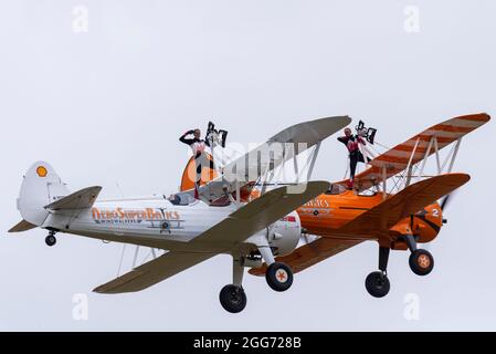 Little Gransden, Cambridgeshire, Royaume-Uni. 29 août 2021. L'équipe de marche en aile d'Aerosuperbatics s'est présentée au Little Gransden Air and car show, un événement organisé pour recueillir des fonds pour la BBC Children in Need Charity. L'équipe vole des biavions Boeing Staarman des années 1940 d'époque avec des rigs sur l'aile supérieure qui permettent aux filles de se manœuvrer dans une variété de positions pendant le vol Banque D'Images