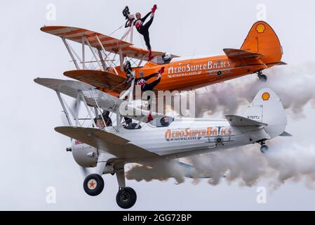 Little Gransden, Cambridgeshire, Royaume-Uni. 29 août 2021. L'équipe de marche en aile d'Aerosuperbatics s'est présentée au Little Gransden Air and car show, un événement organisé pour recueillir des fonds pour la BBC Children in Need Charity. L'équipe vole des biavions Boeing Staarman des années 1940 d'époque avec des rigs sur l'aile supérieure qui permettent aux filles de se manœuvrer dans une variété de positions pendant le vol Banque D'Images