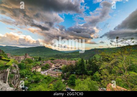 Coucher de soleil sur village médiéval dans la vallée, Santa Fiora, Toscane, Italie. Ciel romantique et nuages au-dessus des montagnes paysage, destination touristique. Banque D'Images