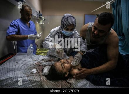 Lian Muhareb, une palestinienne de 10 ans, reçoit un traitement médical après avoir été blessée par un shrapnel lors du bombardement aérien israélien dans sa maison de Khan Yunis, dans le sud de la bande de Gaza, lors de l'escalade entre Israël et Gaza. Bande de Gaza. Banque D'Images