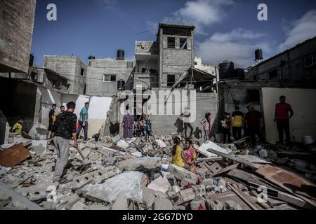 Les Palestiniens inspectent les dommages causés à une maison détruite par une attaque aérienne israélienne dans le sud de la bande de Gaza, dans le contexte de l'escalade des violences entre Israël et Gaza en mai 2021. Bande de Gaza. Banque D'Images