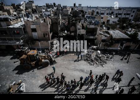 Les Palestiniens inspectent les maisons endommagées et détruites qui ont été touchées par les frappes aériennes israéliennes dans le sud de la bande de Gaza, dans le contexte de l'escalade de la violence entre Israël et Gaza en mai 2021. Bande de Gaza. Banque D'Images