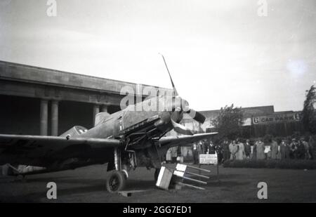 1940s, historique, Fonds Spitfire. Personnes visitant une exposition d'un WW2 avions de chasse allemands endommagés, éventuellement un Messerschmitt, à Birmingham, West Midlands, Angleterre, Le Royaume-Uni dans le cadre d'une initiative visant à recueillir de l'argent pour acheter plus de Spitfires. La collecte de fonds communautaires de ce genre a été tentée pour la première fois en WW1 et, pendant la bataille de la Grande-Bretagne, un fonds Spitfire a été créé pour recueillir des fonds pour l'effort de guerre. Le coût d'un Spitfire a été fixé à une valeur nominale de 5 000 £ et les particuliers, les entreprises et les communautés ont été encouragés à y contribuer. La ville de Birmingham avait quatre Spitfires nommés d'après elle. Banque D'Images