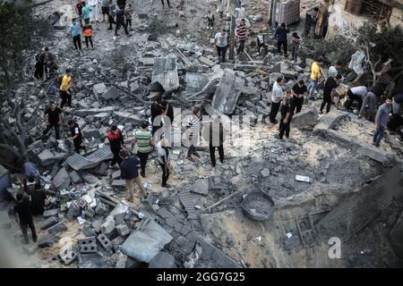 Les Palestiniens inspectent les maisons endommagées et détruites qui ont été touchées par les frappes aériennes israéliennes dans le sud de la bande de Gaza, dans le contexte de l'escalade de la violence entre Israël et Gaza en mai 2021. Bande de Gaza. Banque D'Images