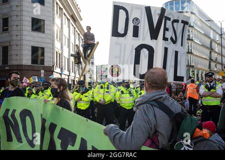 Londres, Royaume-Uni. 27 août 2021. Les militants écologistes de la rébellion d'extinction utilisent trois trépieds pour bloquer une jonction à l'extérieur de la station de métro Mansion House après une marche de l'argent du sang à travers la ville de Londres. Extinction Rebellion avait l'intention de mettre en évidence les institutions financières qui financent des projets de combustibles fossiles, en particulier dans les pays du Sud, ainsi que les cabinets d'avocats et les institutions qui les facilitent, tout en appelant le gouvernement britannique à cesser tous les nouveaux investissements dans les combustibles fossiles avec effet immédiat. Crédit : Mark Kerrison/Alamy Live News Banque D'Images