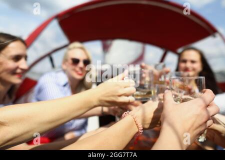 Les jeunes femmes sur le bateau claquent des lunettes et rire Banque D'Images