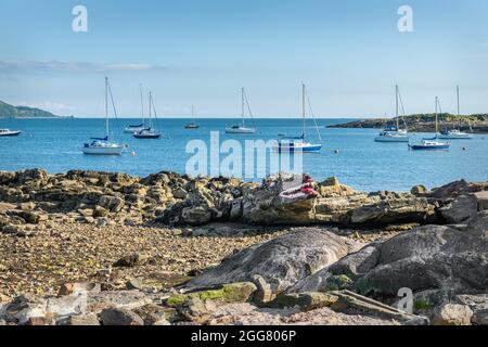 Crocodile Rock sur la plage de Millport sur Cumbrae en Écosse avec l'île d'Eilean dans la baie de Millport. Banque D'Images