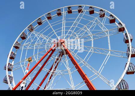 La grande roue tourne une journée ensoleillée au parc d'attractions. Personne Banque D'Images