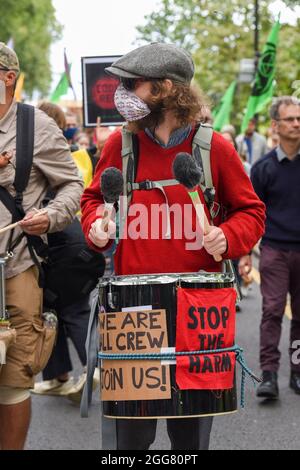 Londres, Royaume-Uni. 29 août 2021. Un batteur vu pendant l'extinction Carnaval de la rébellion pour la justice climatique à Londres, dans le cadre de leurs deux semaines de manifestations impossibles de la rébellion.XR Unify est un groupe dirigé par le BIPOC (Black, Indigenous et People of Color) qui prend des mesures pour mettre un terme à l'industrie des combustibles fossiles. Crédit : SOPA Images Limited/Alamy Live News Banque D'Images