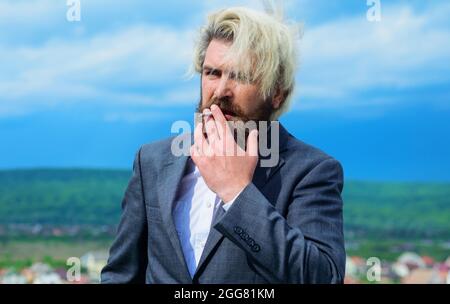 Homme d'affaires en costume fume la cigarette. Fumer homme. Homme barbu élégant avec cigarette. Banque D'Images