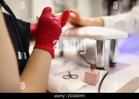 Le maître couvre les ongles des clients avec du gel poli Banque D'Images