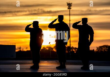 Le personnel des opérations des affaires mortuaires de la Force aérienne salue lors de la formation de nuit au transfert digne à la base aérienne de Douvres, Delaware, le 30 mars 2021. Les événements de formation aident les équipes de transport à se préparer à honorer les membres du service déchus lorsqu'ils retournent aux États-Unis à l'AFB de Douvres. (É.-U. Photo de la Force aérienne par le premier Airman Christopher Quail) Banque D'Images