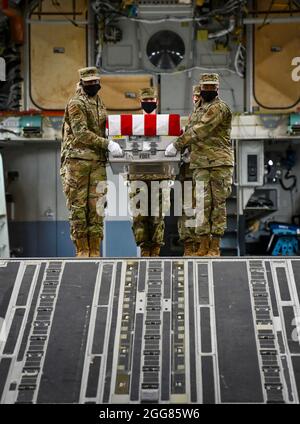 Une équipe de transport de la US Air Force transporte une boîte de transfert d'entraînement pendant l'entraînement de transfert de nuit digne des opérations des affaires mortuaires de la Force aérienne à la base aérienne de Douvres, Delaware, le 30 mars 2021. Les boîtes de transfert utilisées pendant la formation sont pondérées pour simuler la chute d'un membre du service après-vente portant un équipement de protection complet. (É.-U. Photo de la Force aérienne par le premier Airman Christopher Quail) Banque D'Images