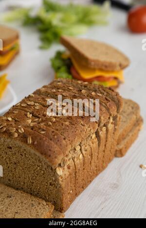 sandwichs préparés avec des ingrédients frais, armés de pain de blé entier, de fromage, de laitue et d'une assiette de nachos sur une table à côté d'un moule en tranches Banque D'Images