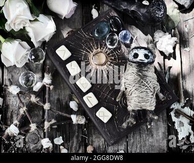 Grunge encore la vie avec la poupée voodoo, livre de sorcière décoré, runes et pentagramme sur planches. Arrière-plan ésotérique, gothique et occulte, Halloween mystique et Banque D'Images