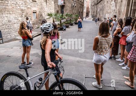 Barcelone, Espagne. 29 août 2021. Un groupe de touristes sont vus à l'écoute d'un "grand opéra diva" dans le quartier de la cathédrale de Barcelone. L'équilibre économique des secteurs économiques qui dépendent du tourisme a fermé en août en dessous des attentes en raison des restrictions de mobilité persistantes découlant de la soi-disant cinquième vague de Covid. Crédit : SOPA Images Limited/Alamy Live News Banque D'Images