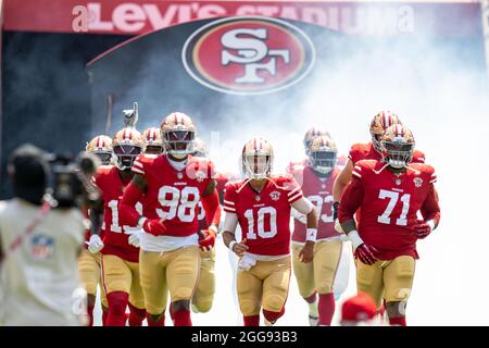 Le quarterback des 49ers de San Francisco, Jimmy Garoppolo (10), court sur le terrain avec l’attaque offensive Trent Williams (71) et l’extrémité défensive Arden Key (98) et ses coéquipiers avant le début du match contre les Raiders de Las Vegas au Levi’s Stadium, dimanche 29 août 2021, à Santa Clara, Calif. (Neville Guard/image du sport) Banque D'Images