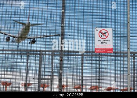 Aucun signe de zone de drone à l'aéroport de Londres Heathrow, Royaume-Uni, avec avion de ligne qui atterrit au-delà. Panneau d'avertissement de périmètre. Pas de vol de drone non autorisé Banque D'Images