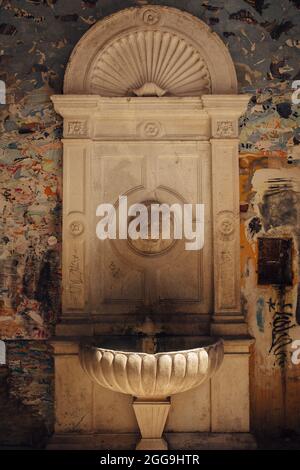 Vieille fontaine à boire aux intempéries avec une sculpture de la tête de lion Banque D'Images