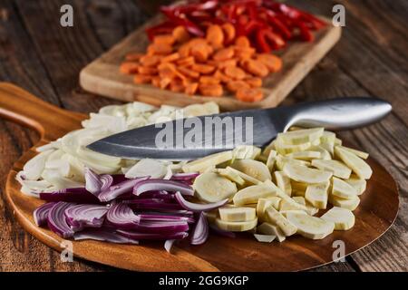 Oignons rouges, blancs et autres légumes sur une planche à découper, fraîchement hachés Banque D'Images