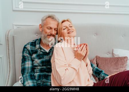 mari et femme ont le petit déjeuner avec du café sur le lit à la maison Banque D'Images